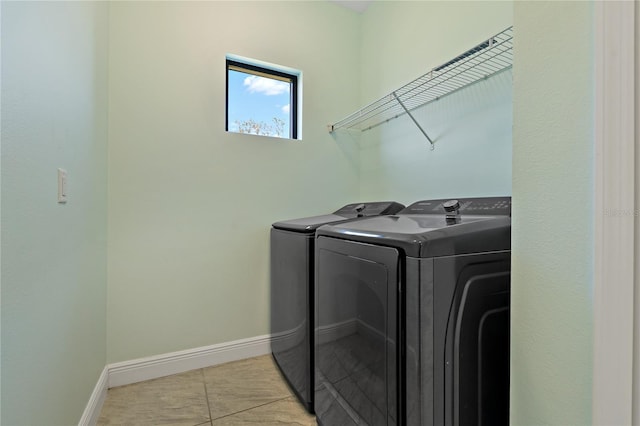 laundry area with washer and clothes dryer and light tile patterned floors