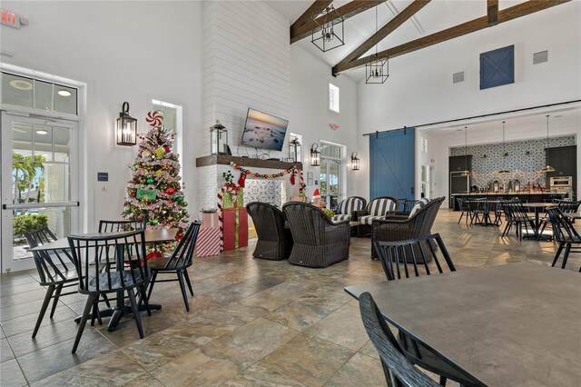 13584 Old Creek Ct, Parrish, FL 34219 - dining room featuring high vaulted ceiling, a barn door, beamed ceiling, and stone finish flooring