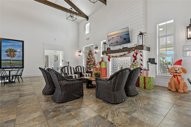 living room featuring beamed ceiling and high vaulted ceiling