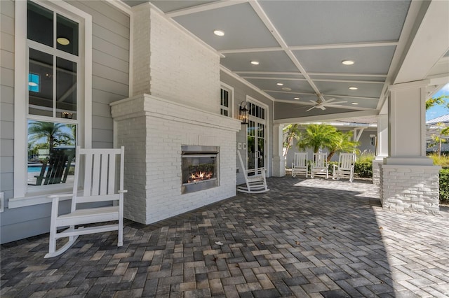 view of patio featuring ceiling fan and an outdoor brick fireplace