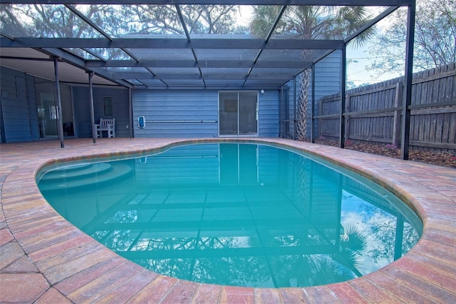 view of pool featuring glass enclosure and a patio area