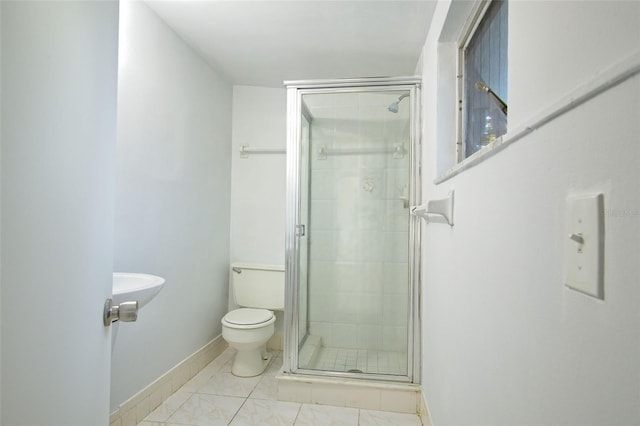 bathroom featuring tile patterned floors, toilet, and an enclosed shower