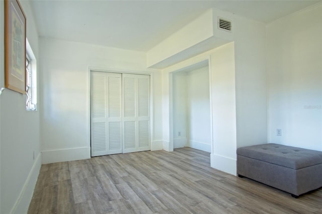 unfurnished bedroom with light hardwood / wood-style floors and a closet