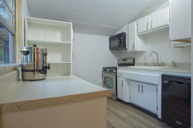 kitchen with sink, black appliances, light hardwood / wood-style flooring, and white cabinets