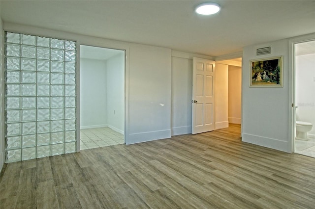 interior space featuring light hardwood / wood-style floors and ensuite bath