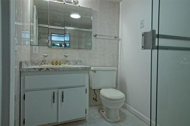 bathroom featuring toilet, tile walls, tile patterned floors, and vanity