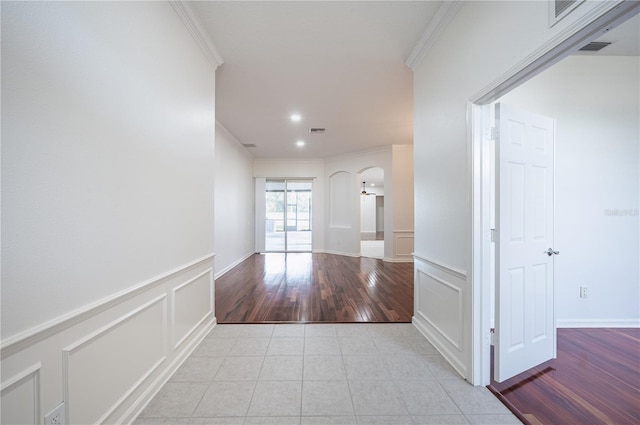 3602 Juneberry Dr, Wesley Chapel, FL 33543 - corridor with ornamental molding, arched walkways, light tile patterned flooring, a decorative wall, and a wainscoted wall