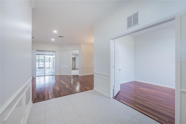 hall with light hardwood / wood-style flooring and crown molding