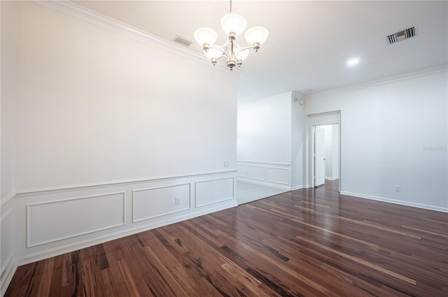 empty room with a chandelier, dark hardwood / wood-style flooring, and crown molding