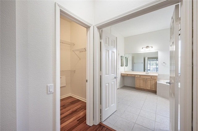 bathroom featuring a washtub, wood-type flooring, and vanity