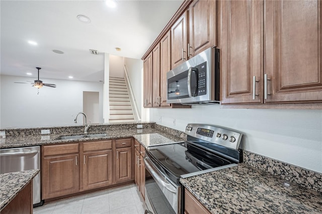 3602 Juneberry Dr, Wesley Chapel, FL 33543 - kitchen with appliances with stainless steel finishes, a sink, dark stone counters, brown cabinetry, and recessed lighting