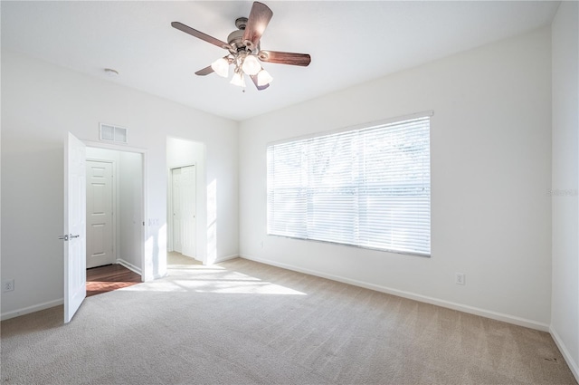 unfurnished bedroom with a closet, light colored carpet, and ceiling fan