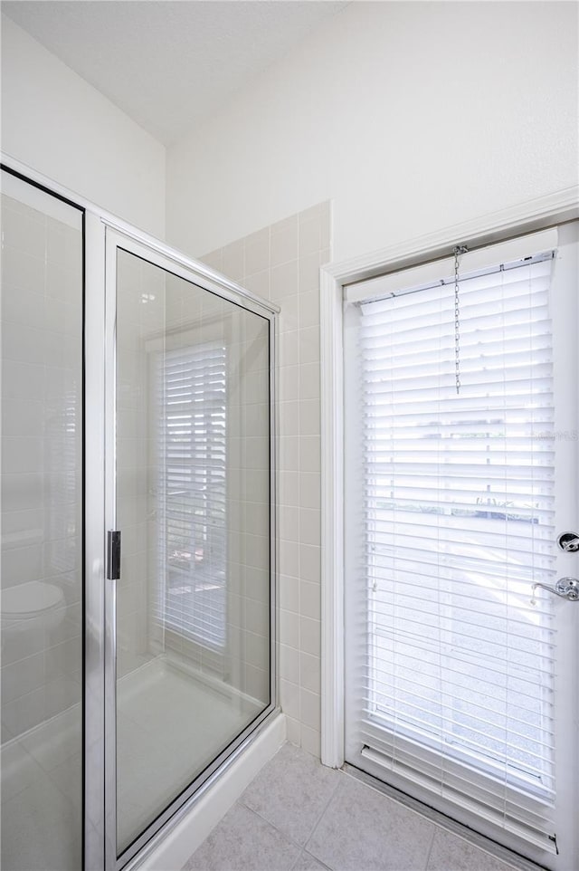 bathroom featuring tile patterned flooring and an enclosed shower