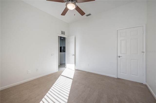 carpeted spare room with ceiling fan