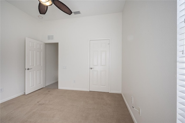 spare room featuring light carpet and ceiling fan