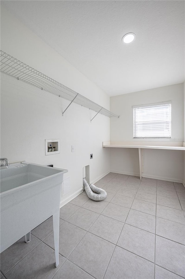 clothes washing area featuring sink, light tile patterned floors, washer hookup, and hookup for an electric dryer