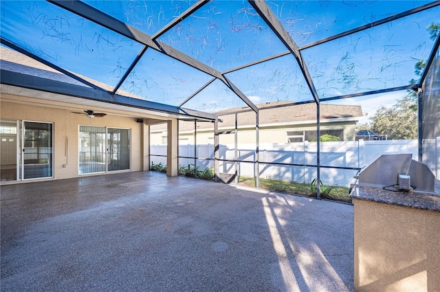 view of patio / terrace with ceiling fan, a lanai, and exterior kitchen