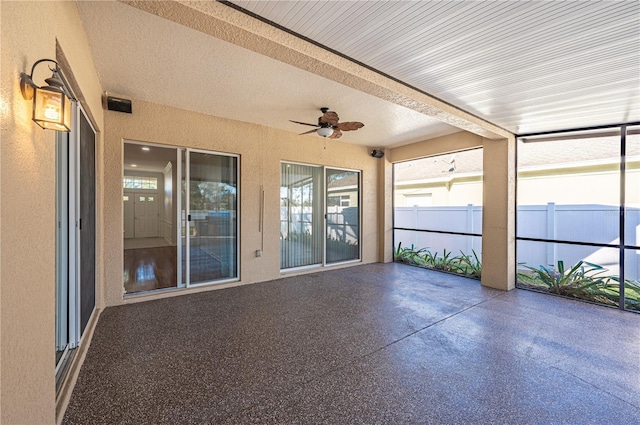 unfurnished sunroom featuring ceiling fan