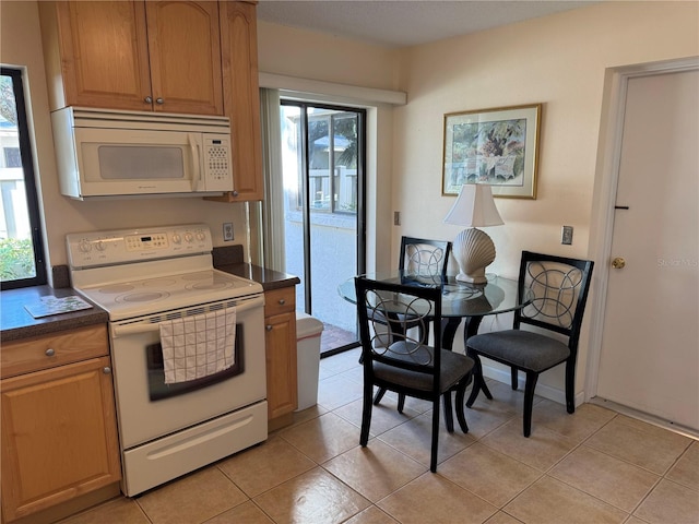 kitchen featuring light tile patterned floors and white appliances