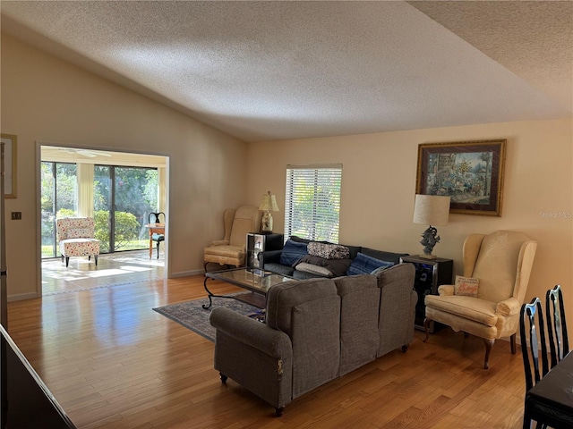 living room with plenty of natural light, light wood-type flooring, and lofted ceiling