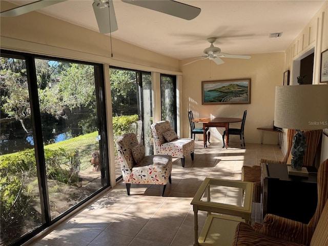 sunroom with a water view and ceiling fan