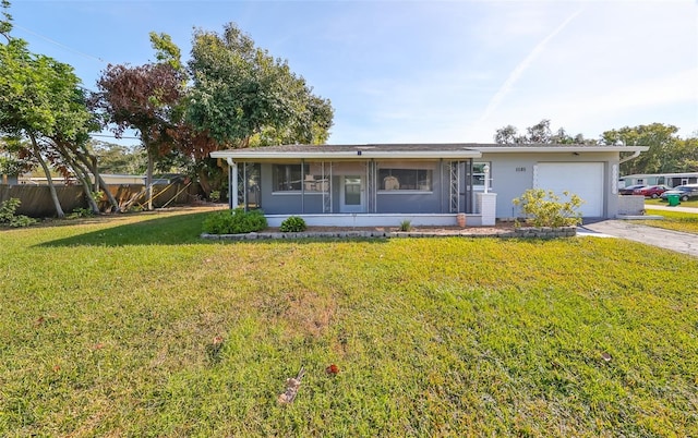 single story home featuring a sunroom, a garage, and a front lawn