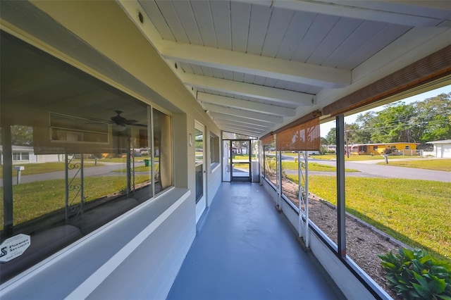 sunroom with lofted ceiling with beams, ceiling fan, and a healthy amount of sunlight