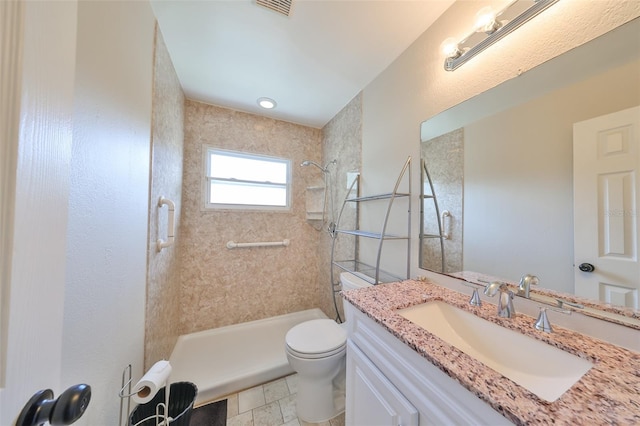 bathroom featuring tile patterned flooring, vanity, toilet, and a tile shower