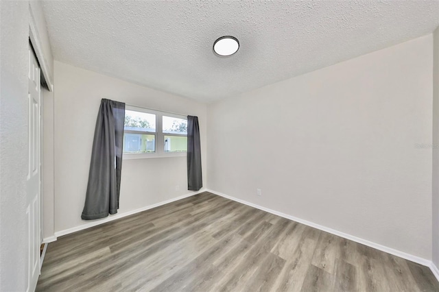 empty room featuring hardwood / wood-style floors and a textured ceiling