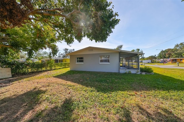 view of side of property with a sunroom and a yard