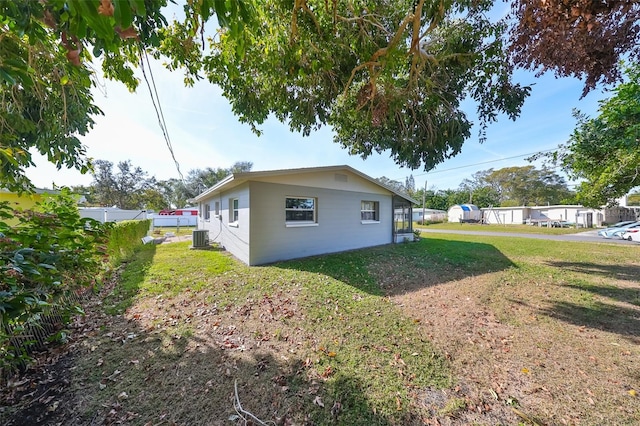 view of home's exterior with a lawn and central AC unit