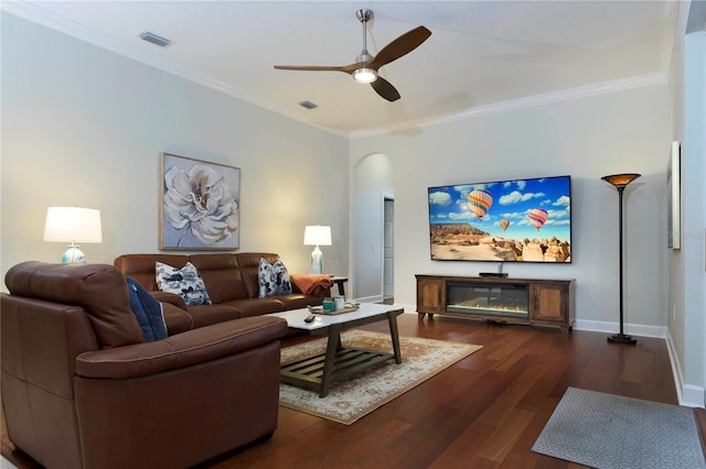 living room with ceiling fan, dark wood-type flooring, and ornamental molding