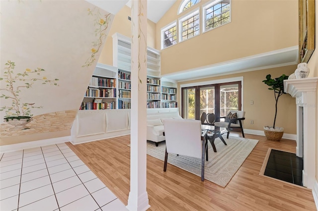 interior space featuring built in shelves, a towering ceiling, and light hardwood / wood-style flooring