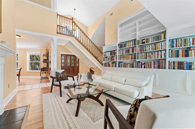 sitting room featuring crown molding, a towering ceiling, and wood-type flooring