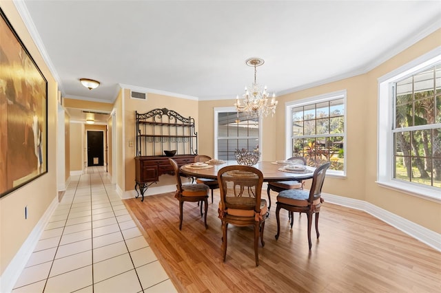 dining space with a chandelier, light wood-type flooring, and ornamental molding