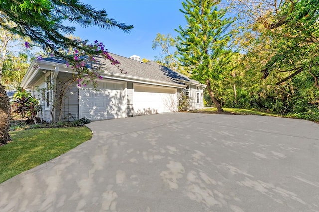 view of side of property with a lawn and a garage