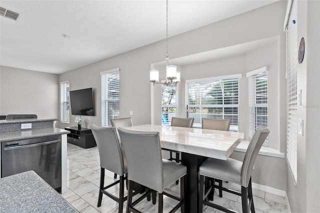 dining area with an inviting chandelier, a textured ceiling, and a healthy amount of sunlight