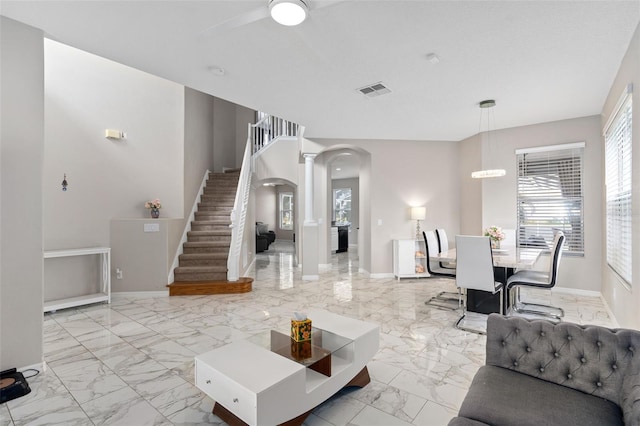 living room featuring decorative columns and ceiling fan