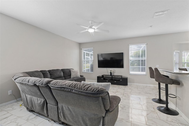 living room featuring ceiling fan, plenty of natural light, and a textured ceiling