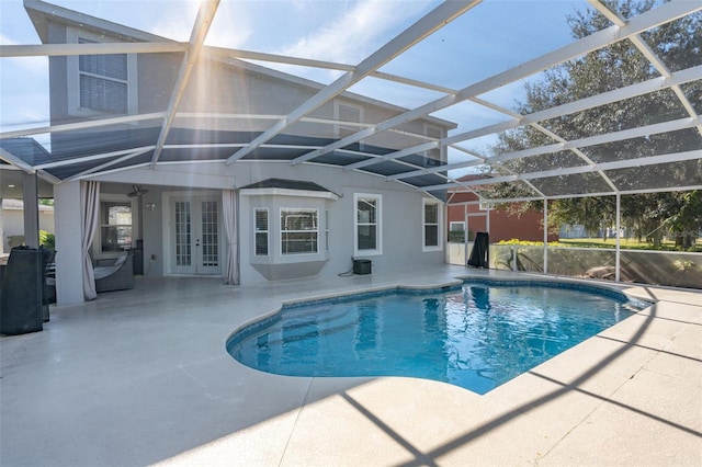 view of pool with a patio, glass enclosure, and french doors