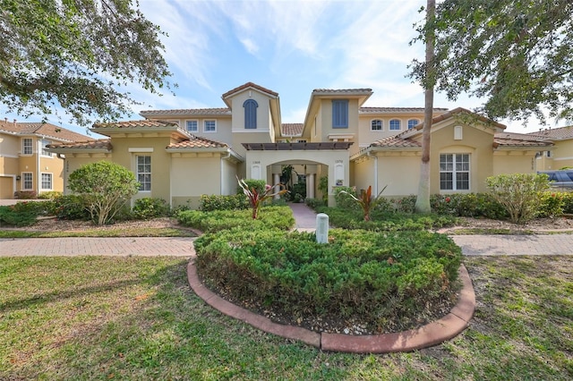 mediterranean / spanish house with a front yard