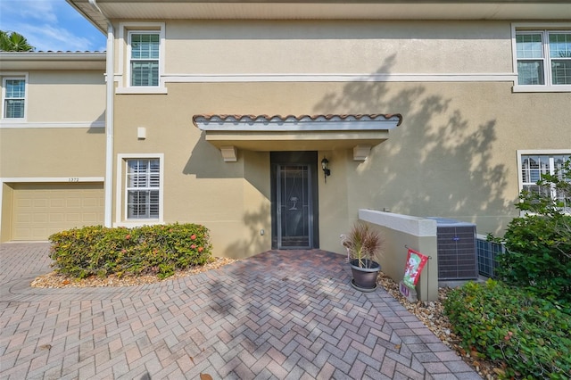 property entrance with central AC and a garage