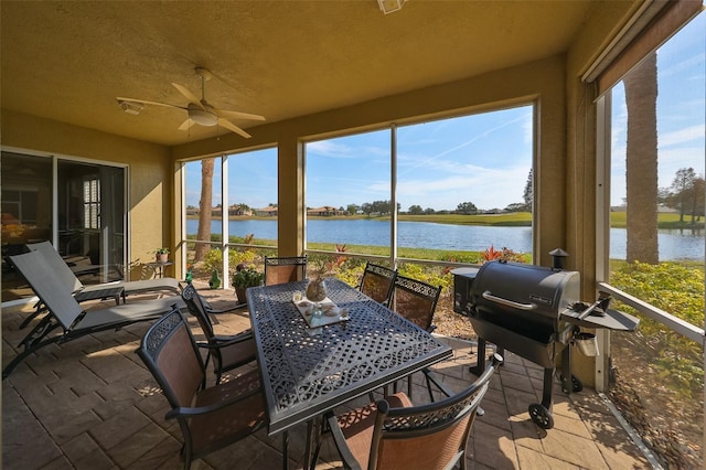 sunroom / solarium with ceiling fan, a healthy amount of sunlight, and a water view