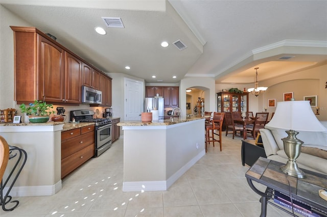 kitchen featuring hanging light fixtures, stainless steel appliances, an inviting chandelier, light tile patterned floors, and ornamental molding