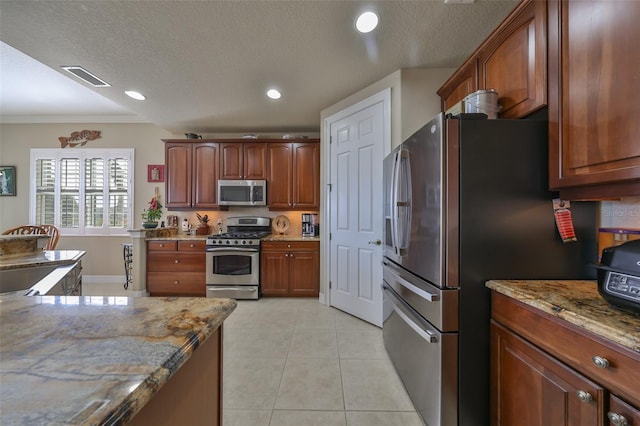 kitchen with light stone countertops, a textured ceiling, stainless steel appliances, and crown molding