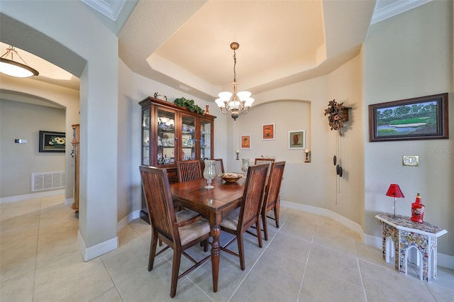 dining room featuring a notable chandelier, light tile patterned floors, and a tray ceiling