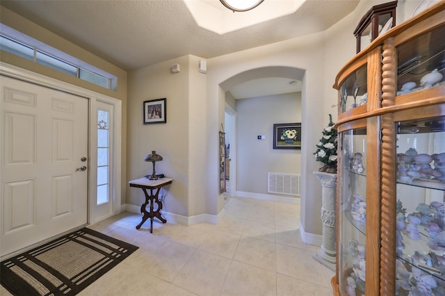 foyer with light tile patterned flooring and a textured ceiling