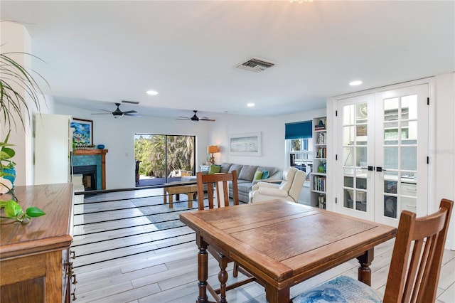 dining space with ceiling fan, french doors, and light hardwood / wood-style floors