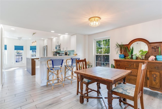 dining area featuring an inviting chandelier and light hardwood / wood-style flooring