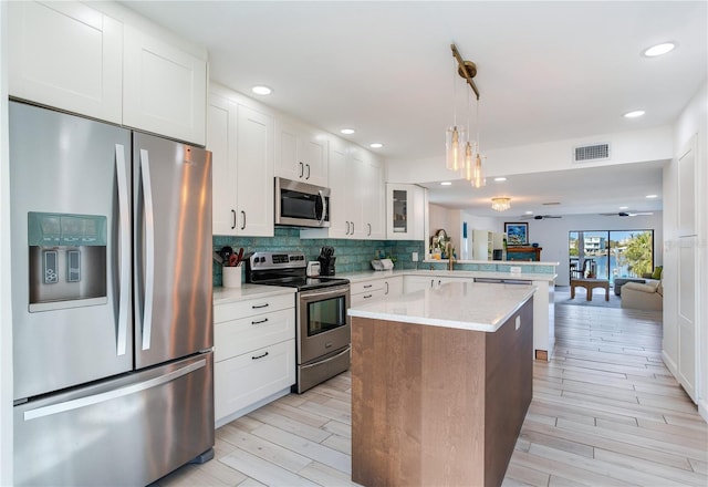 kitchen featuring light hardwood / wood-style floors, white cabinetry, kitchen peninsula, and appliances with stainless steel finishes